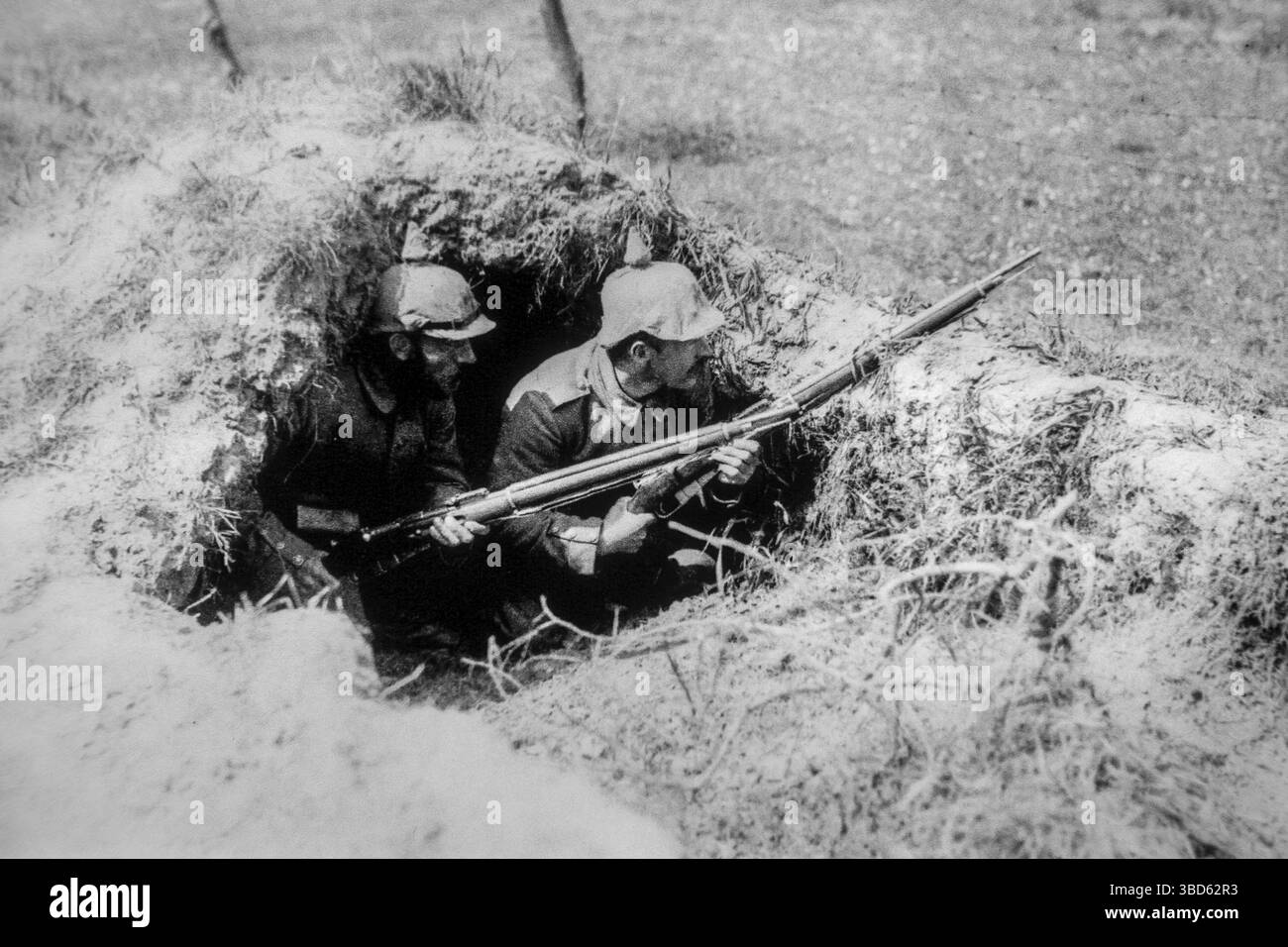 Due soldati tedeschi del Landsturm della prima guerra mondiale del 1916 con Pickelhaube, caschi a punta in foxhole, scavati sul campo di battaglia della prima guerra mondiale nel nord della Francia Foto Stock