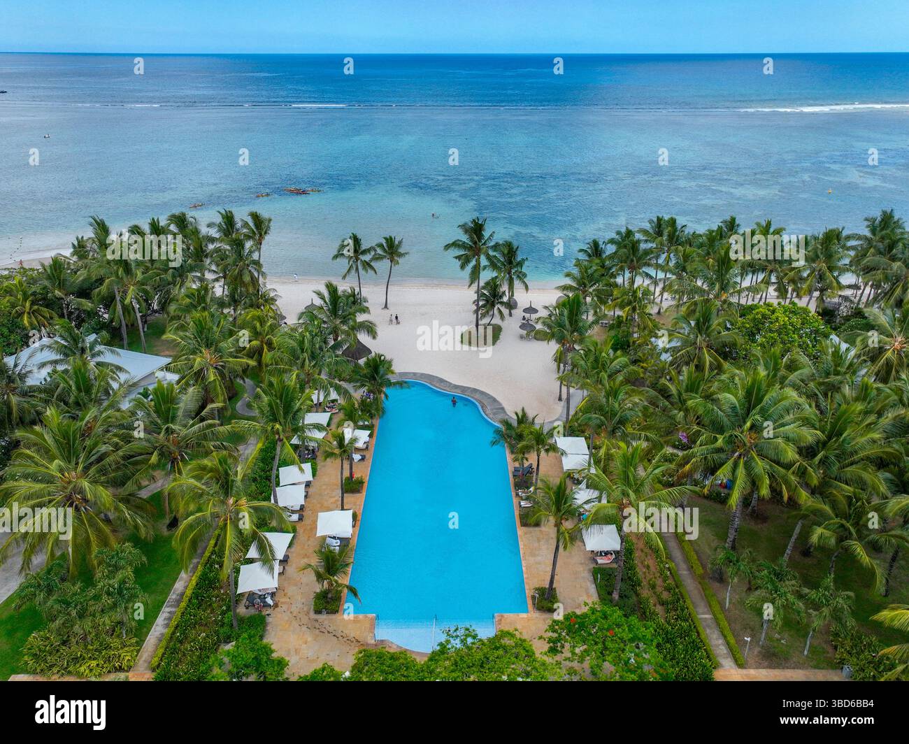 Flic en Flac, Mauritius: Piscina del resort centrale circondata da palme che conducono alla spiaggia Foto Stock