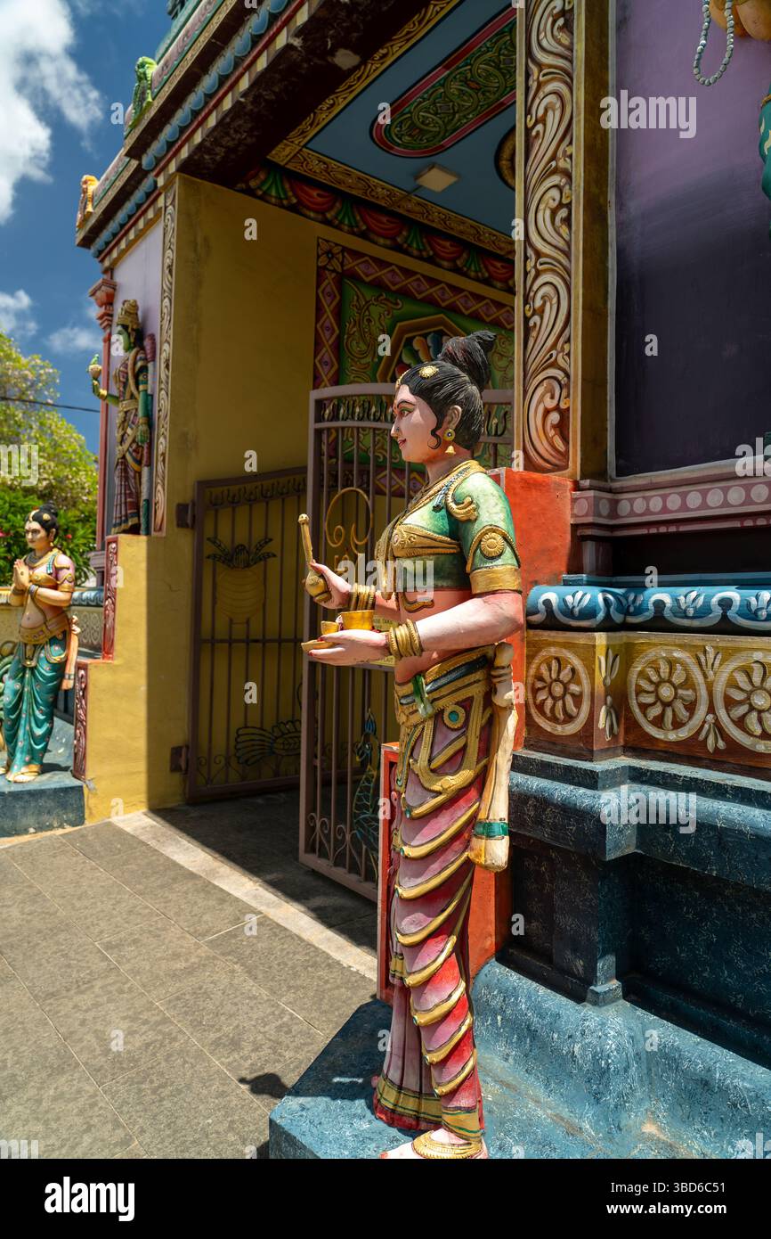 Cap Malheureux, Mauritius - 12 maggio 2024: Divinità femminile scolpita che tiene una lampada all'ingresso di un tempio indù Foto Stock