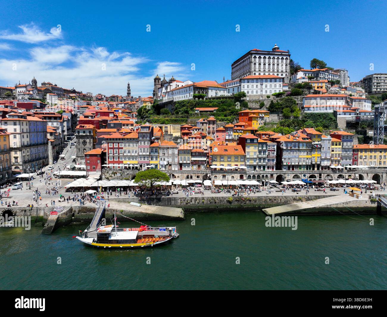 Porto, Portogallo - 12 maggio 2024: Vista sul lungomare di Ribeira con case vivaci e barca ormeggiata Foto Stock