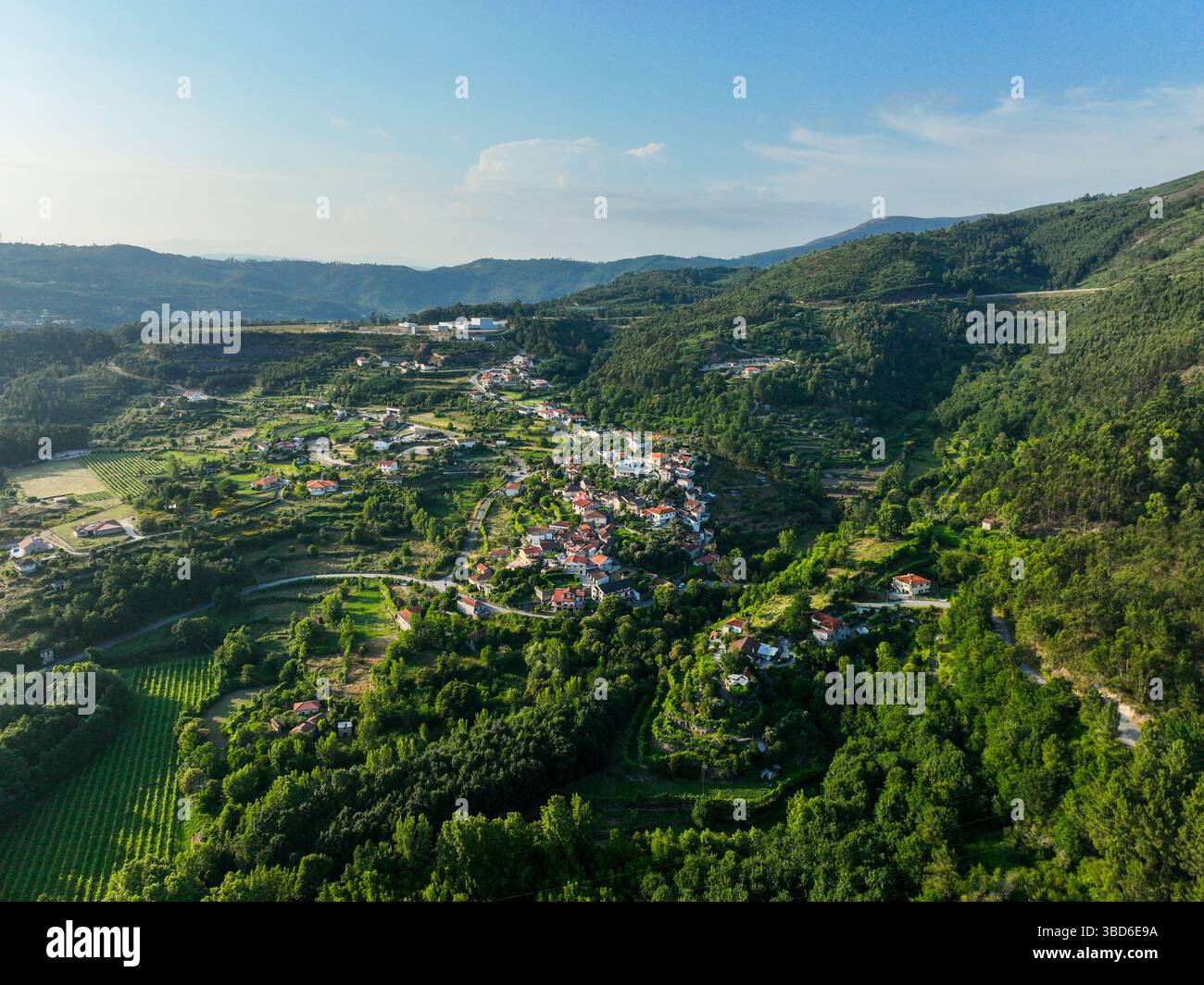 Aerea panoramica del villaggio di Gião abbracciata da alberi e campi coltivati Foto Stock