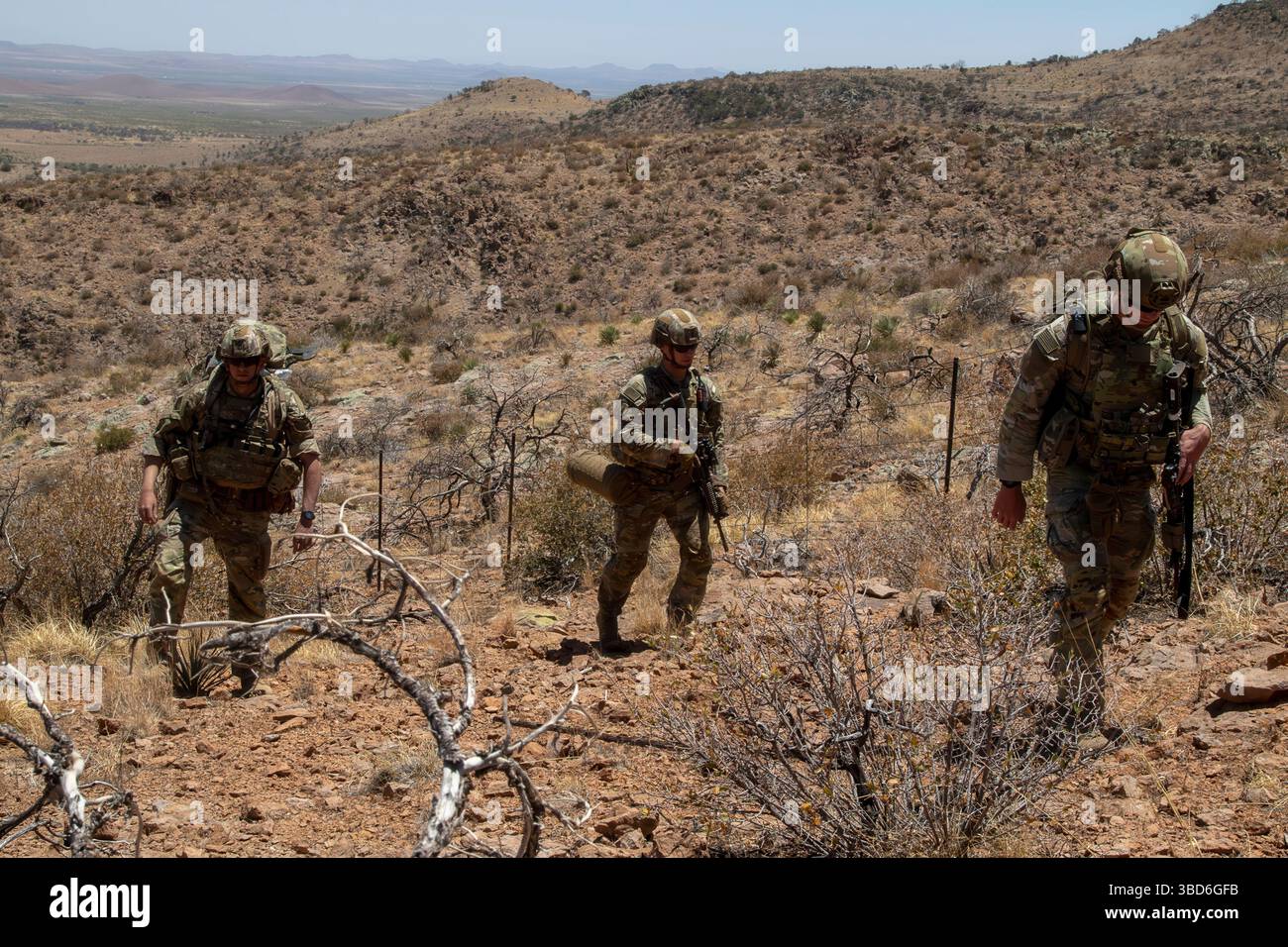 Soldati statunitensi, assegnati alla 76th Engineer Company, 41st Engineer Battalion, con Joint Task Force–Southern Border, scalano il terreno roccioso lungo il confine meridionale durante una missione di deposito dei segni della New Mexico National Defense area (NMNDA) nei pressi di Antelope Wells, New Mexico, 20 maggio 2025. Sotto la direzione del Northern Command degli Stati Uniti, la Joint Task Force–Southern Border allinea gli sforzi per sigillare il confine meridionale e respingere le attività illegali ed è responsabile di operazioni su larga scala, agili e di tutti i domini, che consentiranno operazioni DoD più efficaci ed efficienti. (Foto U.S. Army di SPC. Anjelica Foto Stock