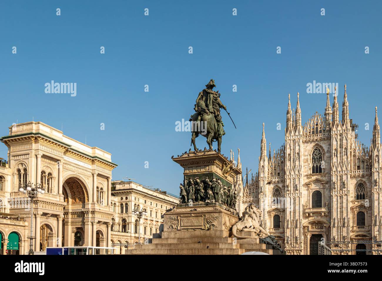 Vista serale del Duomo di Milano illuminato nel cuore della città, con persone che camminano su Piazza del Duomo. La scena si riflette Foto Stock