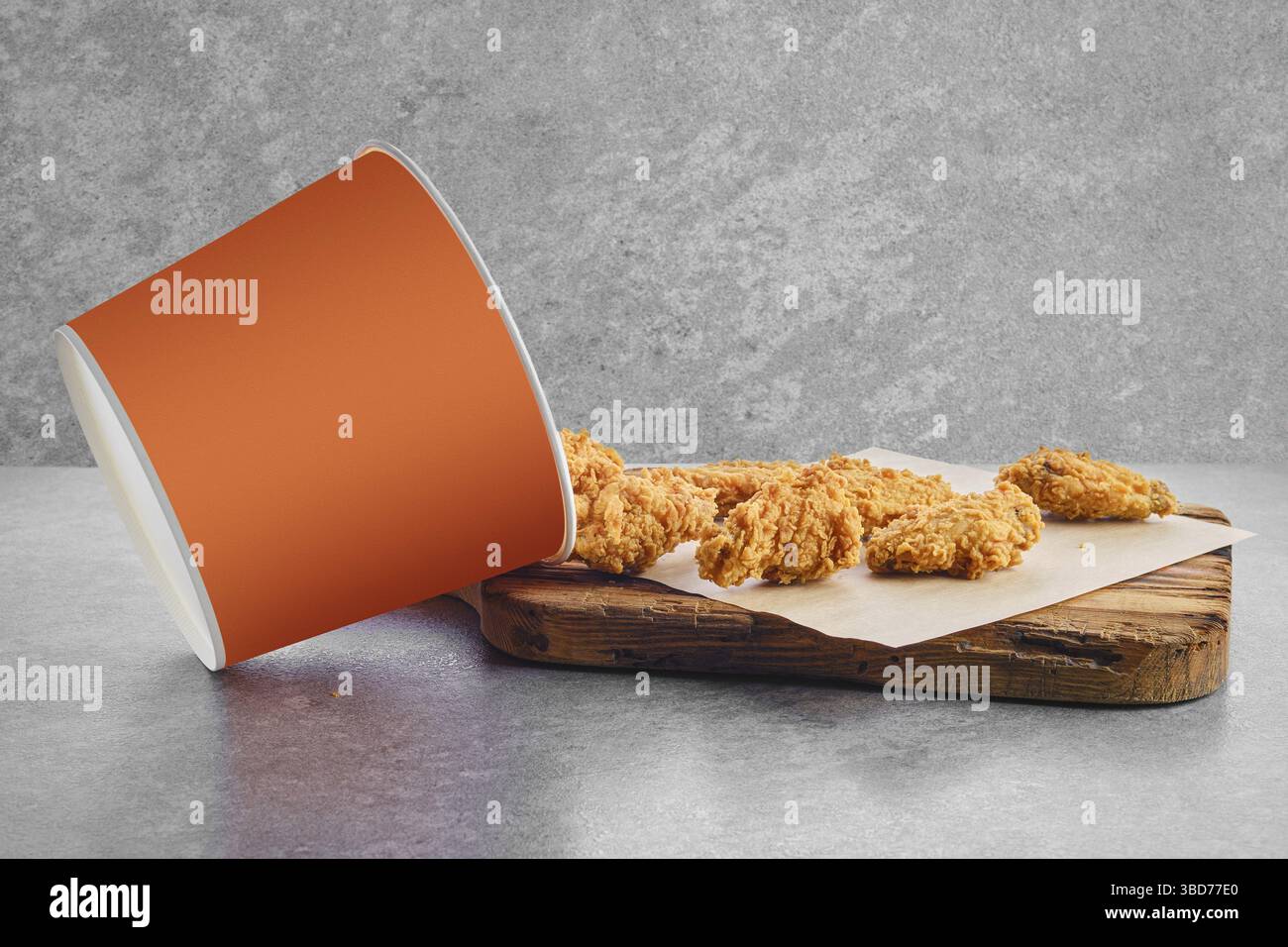 Cestello con ali di pollo fritte in panatura sparsi su carta pergamena Foto Stock