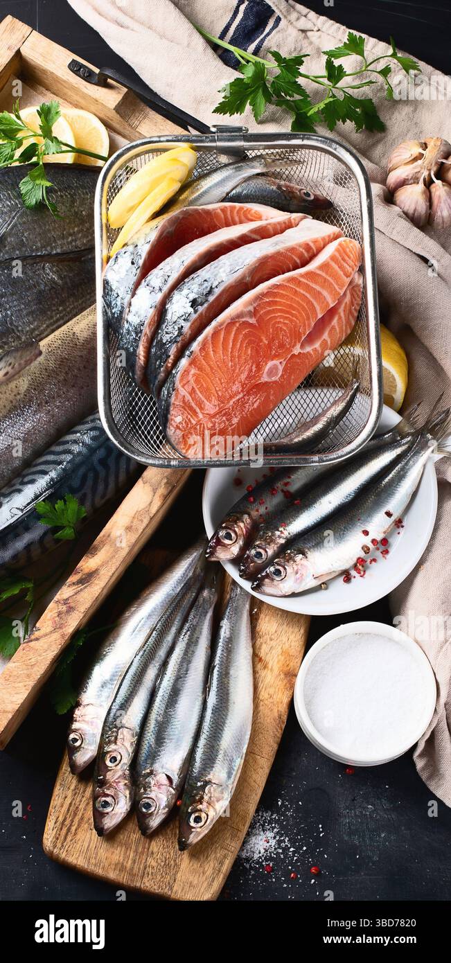 Assortimento di pesce fresco su sfondo nero. Vista dall'alto. Foto Stock