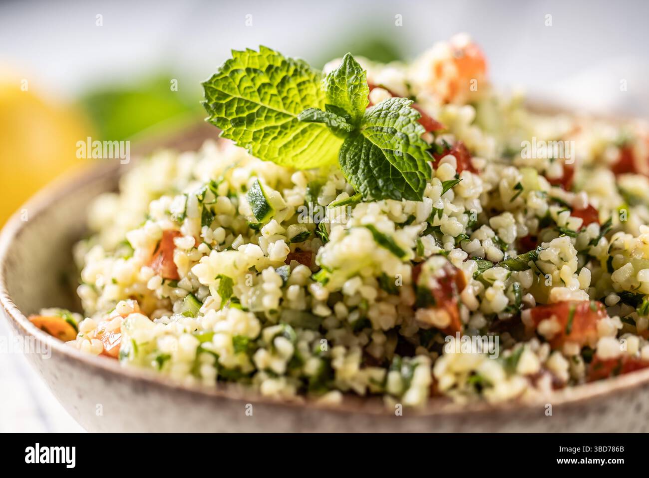 Insalata tradizionale di Tabouleh con bulgur, prezzemolo, cetrioli, pomodoro, coriandolo, aglio, menta e altri ingredienti. Foto Stock