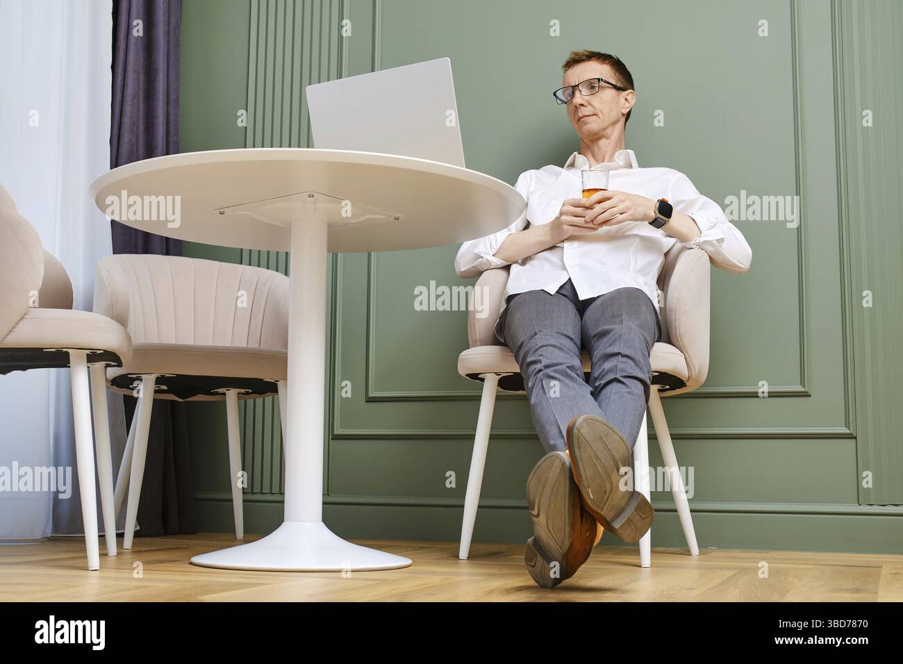 Uomo di mezza età che si rilassa davanti a un notebook a casa Foto Stock