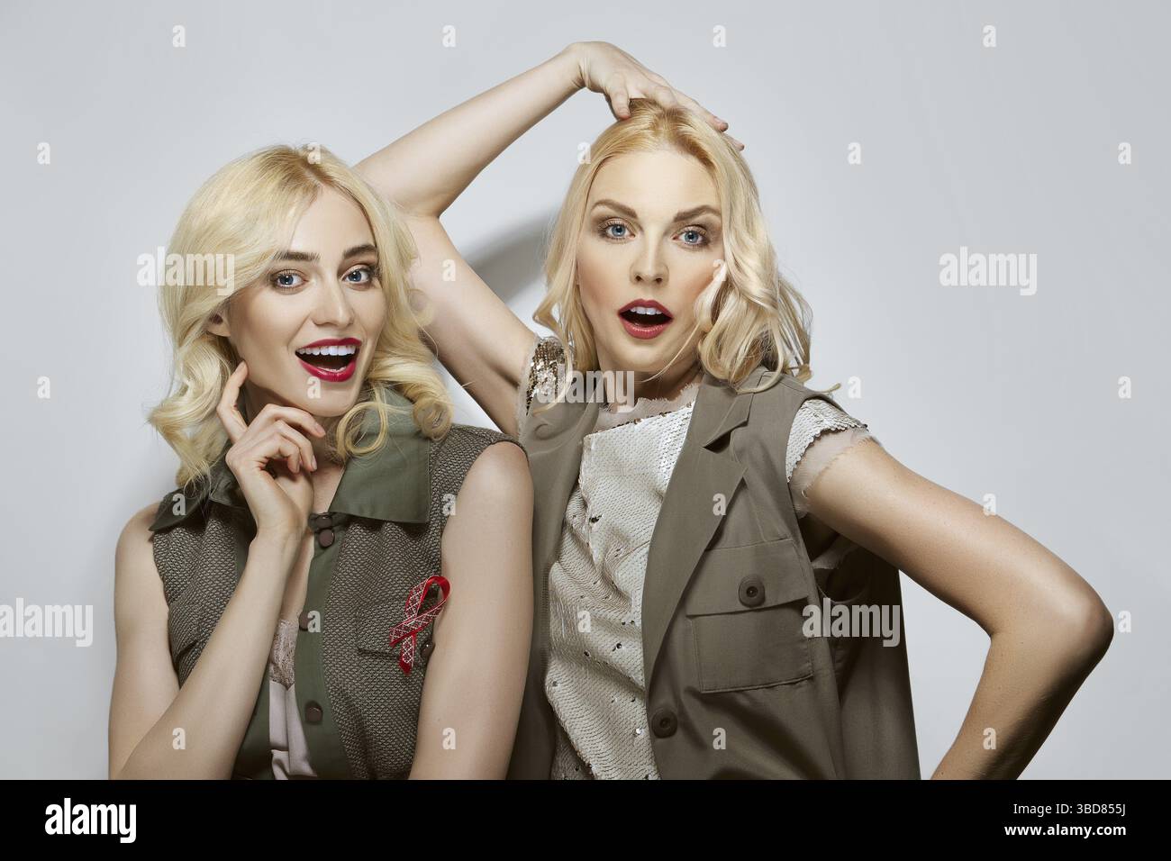 Due belle modelle bionde suonano la scimmia. Creare facce Foto Stock