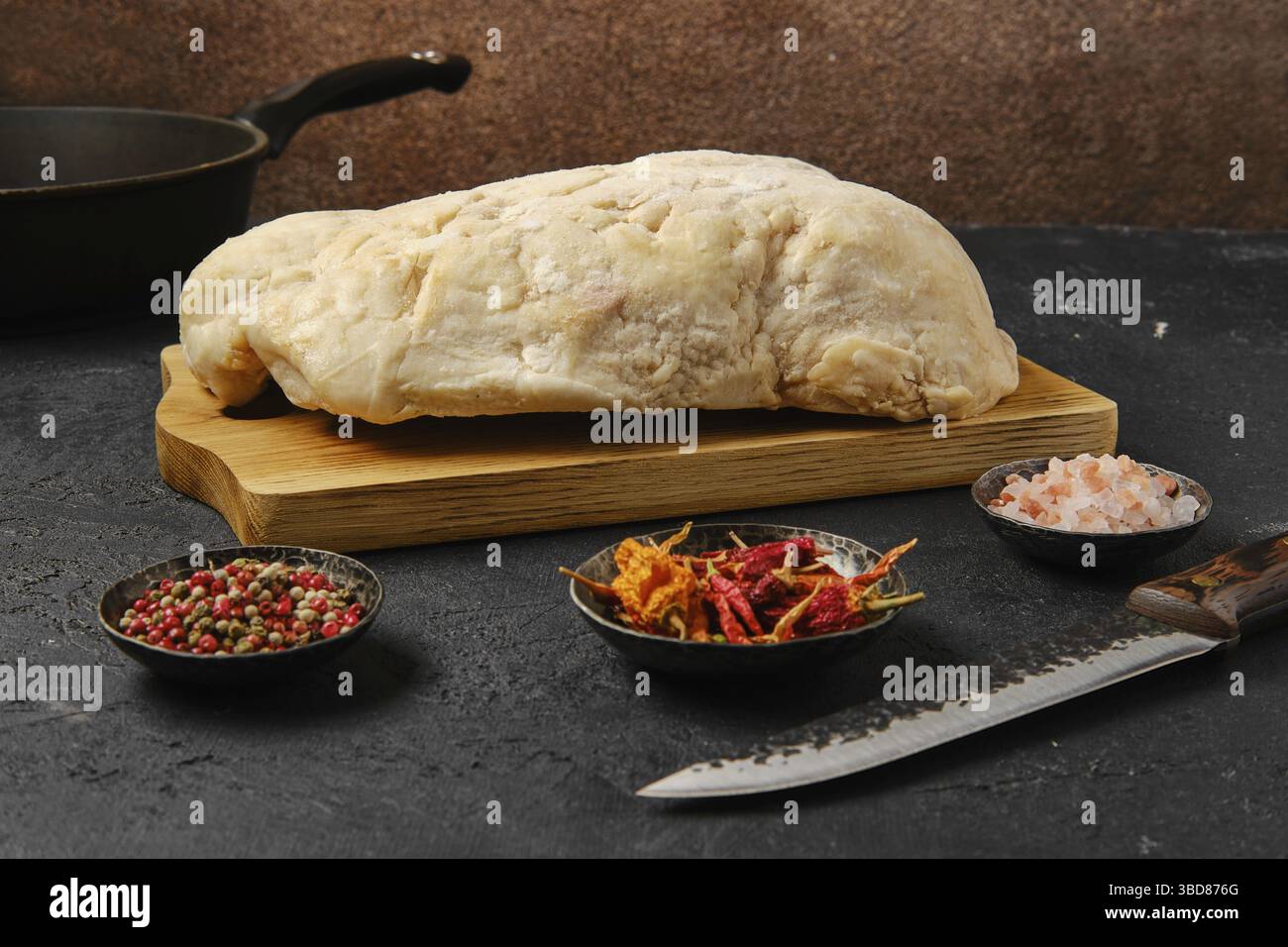 Coda di grasso di agnello sul tavolo da cucina con sale e pepe Foto Stock