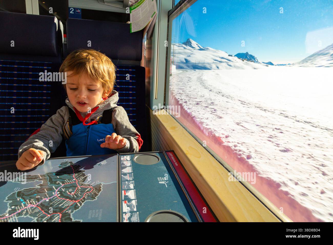 Bambino che gioca durante il viaggio sul treno Bernina Express, Svizzera Foto Stock