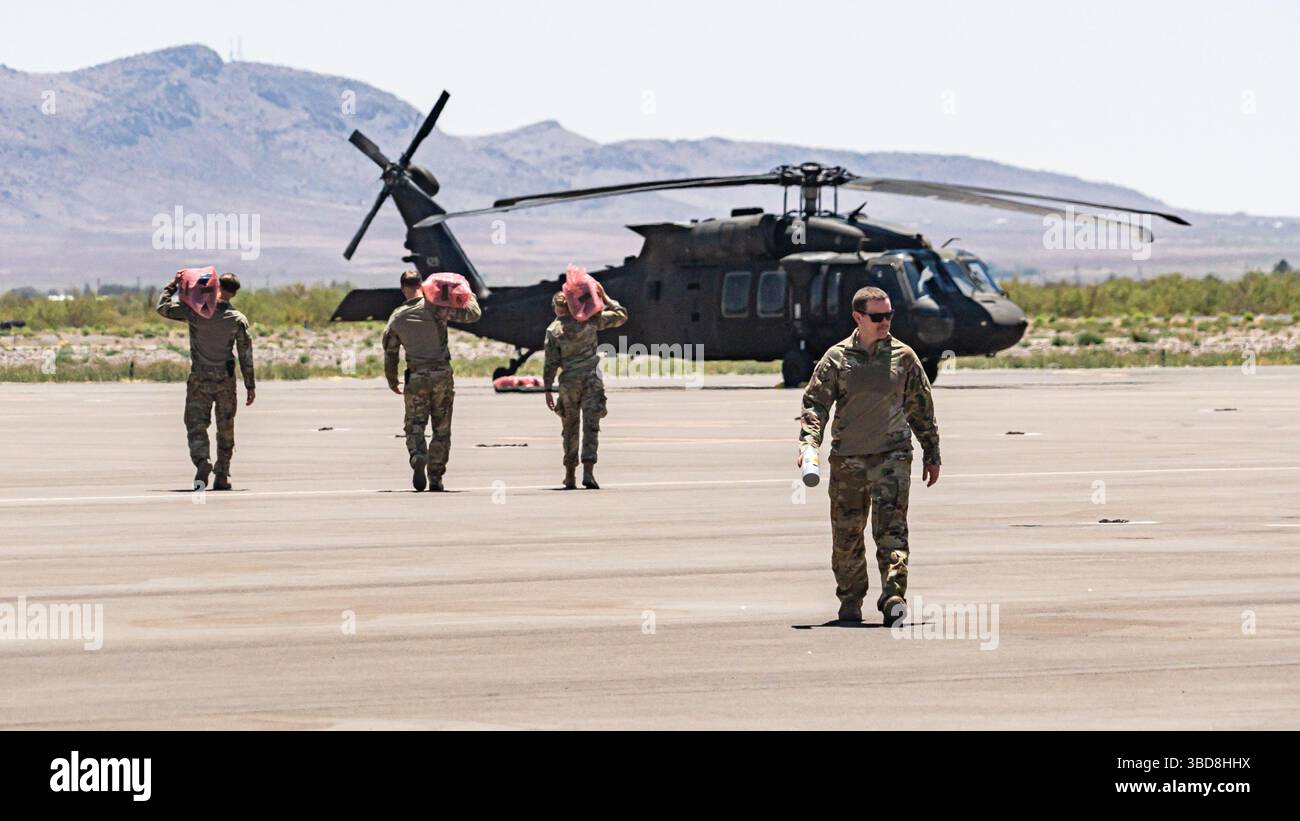 I soldati dell'esercito statunitense, 1st Combat Aviation Brigade, 1st Infantry Division, assegnati alla Joint Task Force–Southern Border, trasportano rifornimenti per la missione di deposito del New Mexico National Defense area (NMNDA) su un elicottero UH-60 Black Hawk vicino a Deming, New Mexico, 20 maggio 2025. I materiali sono stati forniti dalla consegna aerea a causa del terreno austero che limitava le manovre a terra. Sotto la direzione del Northern Command degli Stati Uniti, la Joint Task Force–Southern Border allinea gli sforzi per sigillare il confine meridionale e respingere le attività illegali ed è responsabile di operazioni su larga scala, agili e di tutti i domini, che wi Foto Stock
