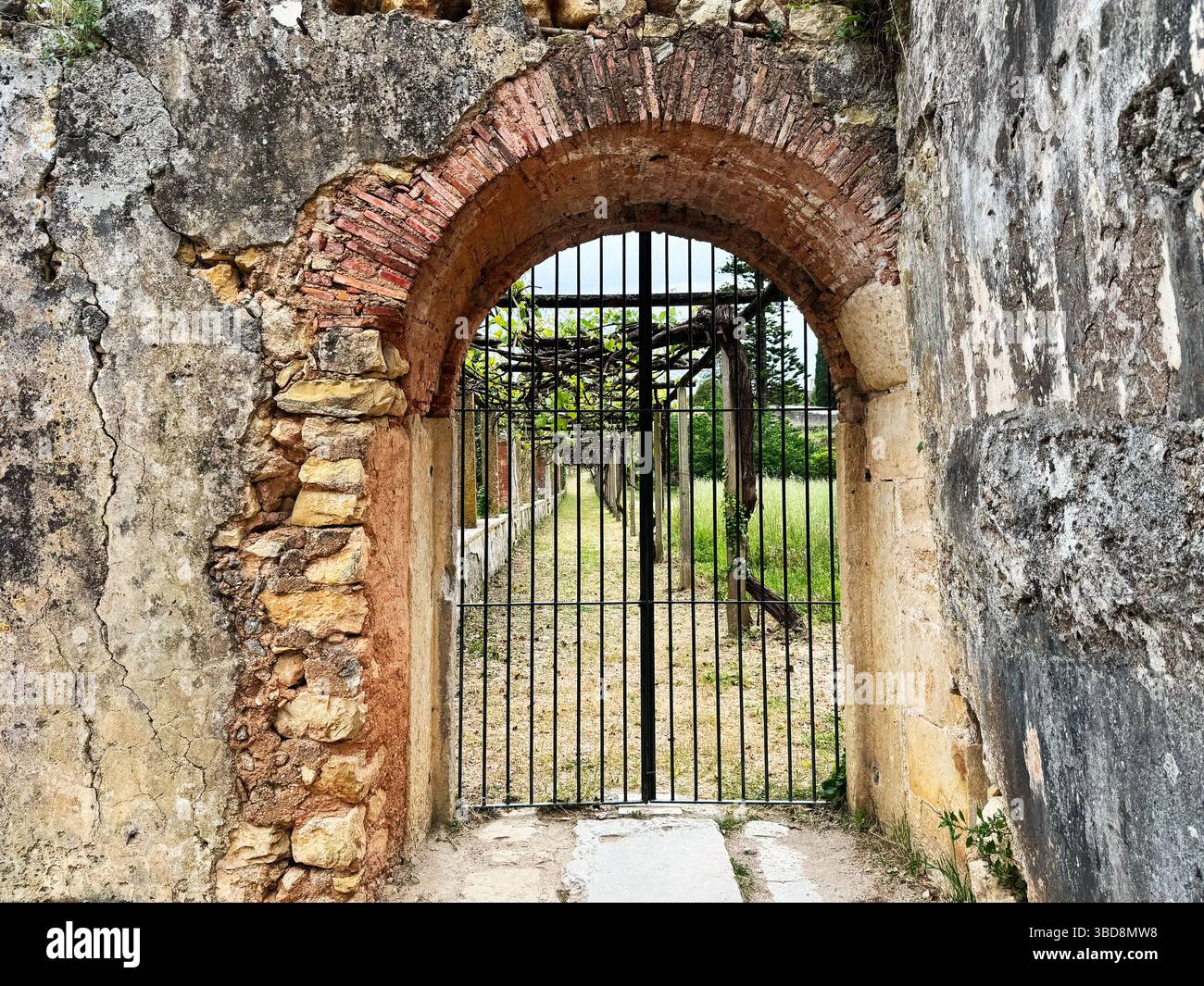 Le mura e le porte in pietra del castello di Tomar, in Portogallo, si aprono su dintorni lussureggianti. Foto Stock