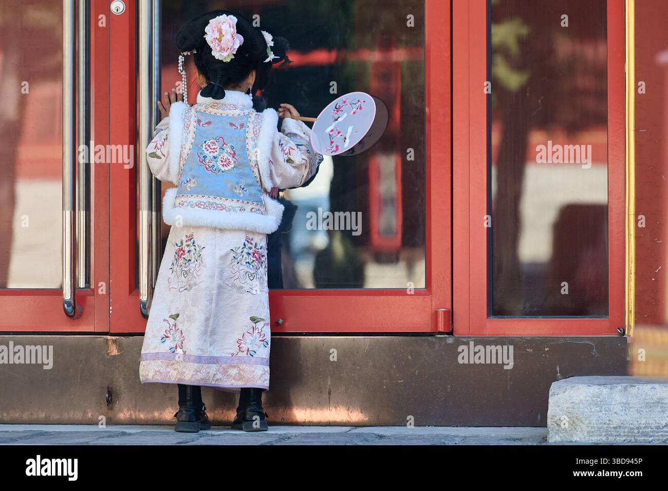 Playful Girl di Hanfu si posa drammaticamente contro un muro del Tempio Rosso Foto Stock