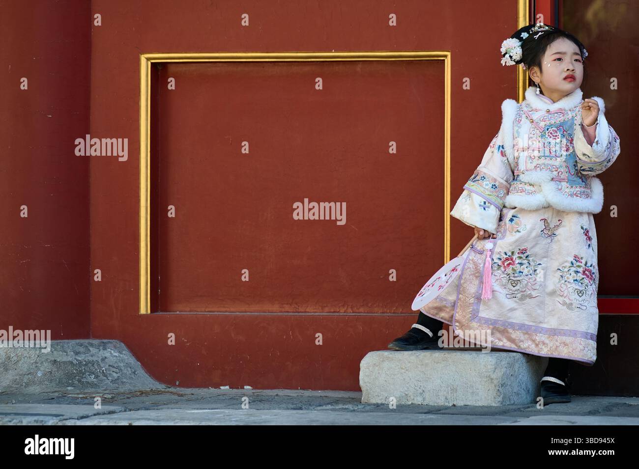 Playful Girl di Hanfu si posa drammaticamente contro un muro del Tempio Rosso Foto Stock