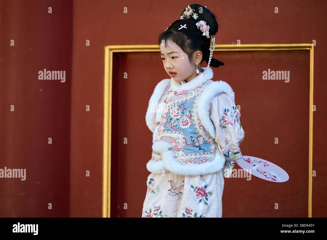 Playful Girl di Hanfu si posa drammaticamente contro un muro del Tempio Rosso Foto Stock