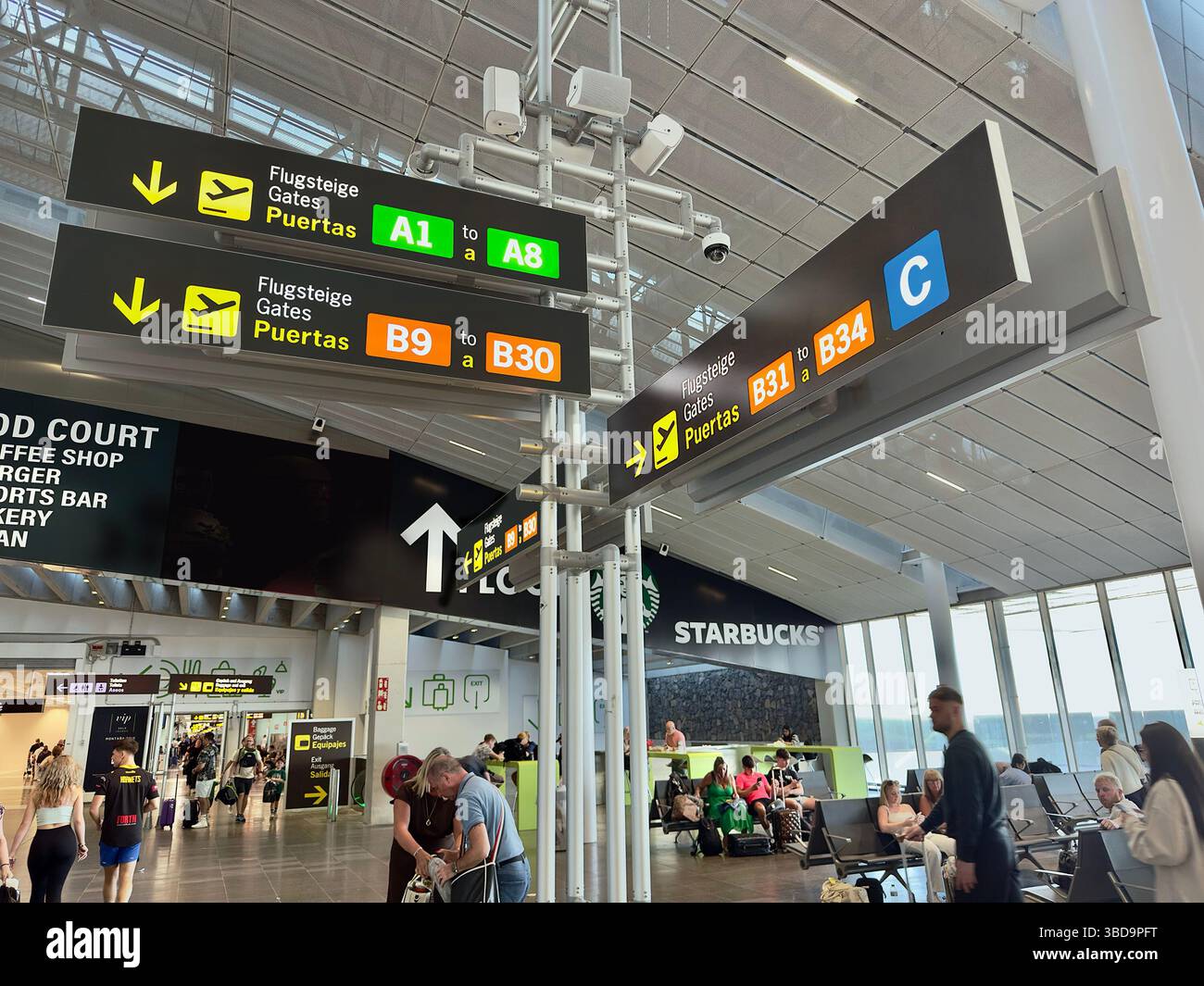 Cartello con la direzione dei terminali appeso al soffitto nel terminal dell'aeroporto di Tenerife sur Foto Stock