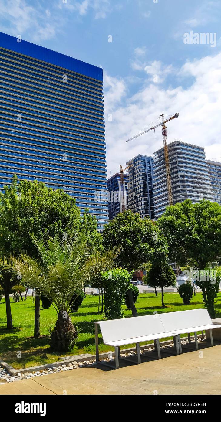 Alti e moderni edifici in costruzione contrastano con vecchi appartamenti residenziali in un parco cittadino. La trasformazione urbana e lo scontro tra architetti Foto Stock