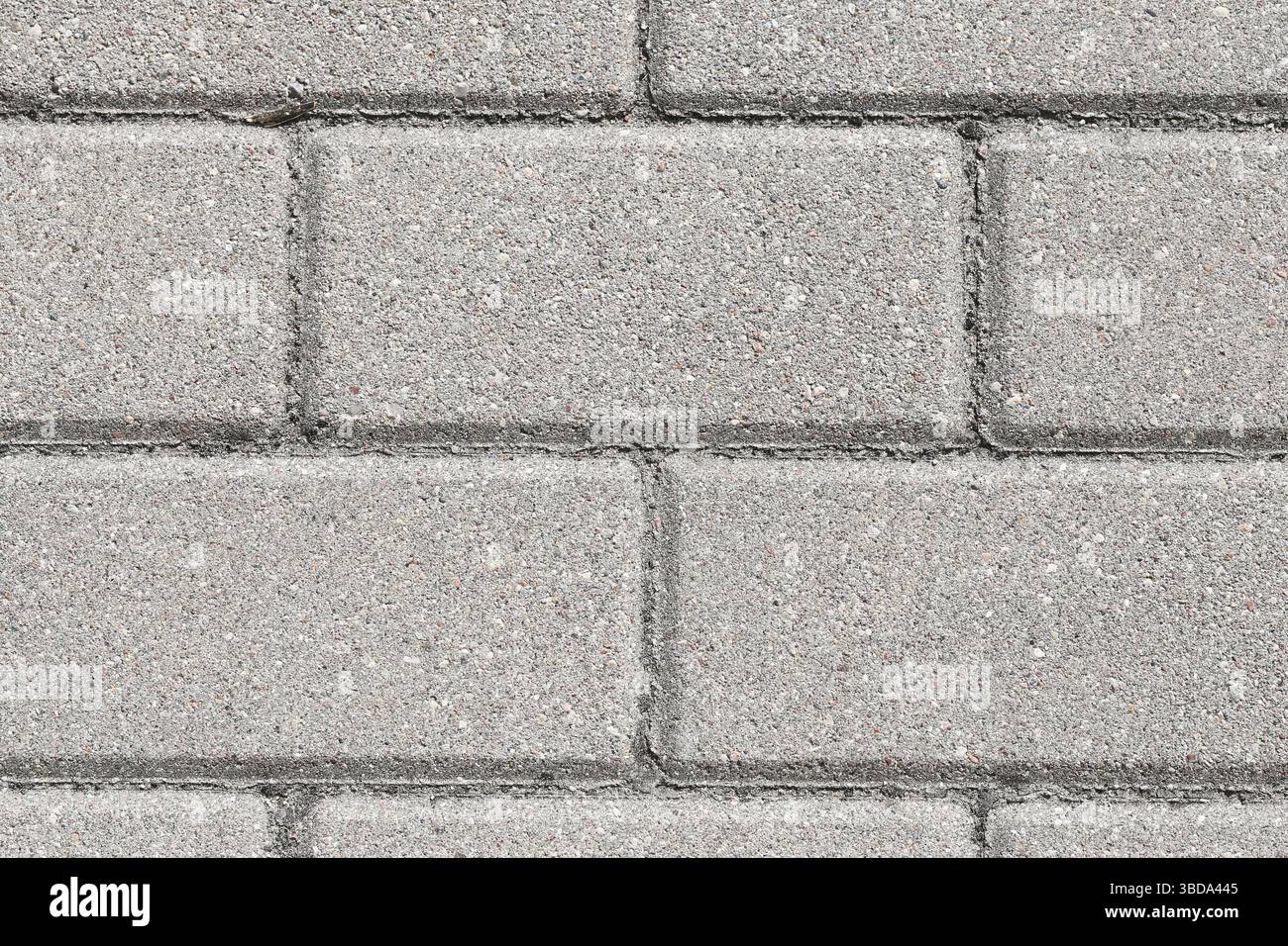 Struttura di pavimentazione in calcestruzzo grigio. Modello di marciapiede urbano. Pulire i mattoni piatti alla luce del sole. Superficie industriale ruvida. Struttura e design minimalisti. Foto Stock