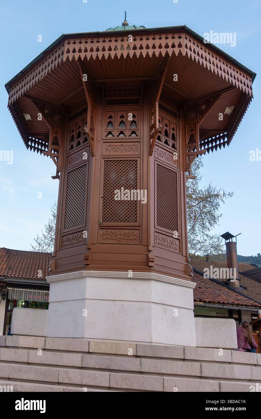 Sebilj a Sarajevo. Una fontana di legno splendidamente realizzata occupa una posizione prominente nella città vecchia. Al crepuscolo, inonda la fontana di luce soffusa Foto Stock