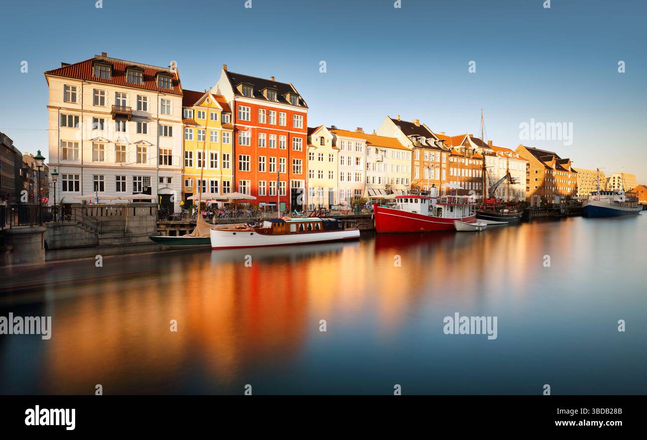Nyhavn Pedestrian Waterfront Street: Caffetterie all'aperto ed edifici colorati. Nyhavn (Porto nuovo) è un lungomare del XVII secolo, canale e quartiere del divertimento Foto Stock