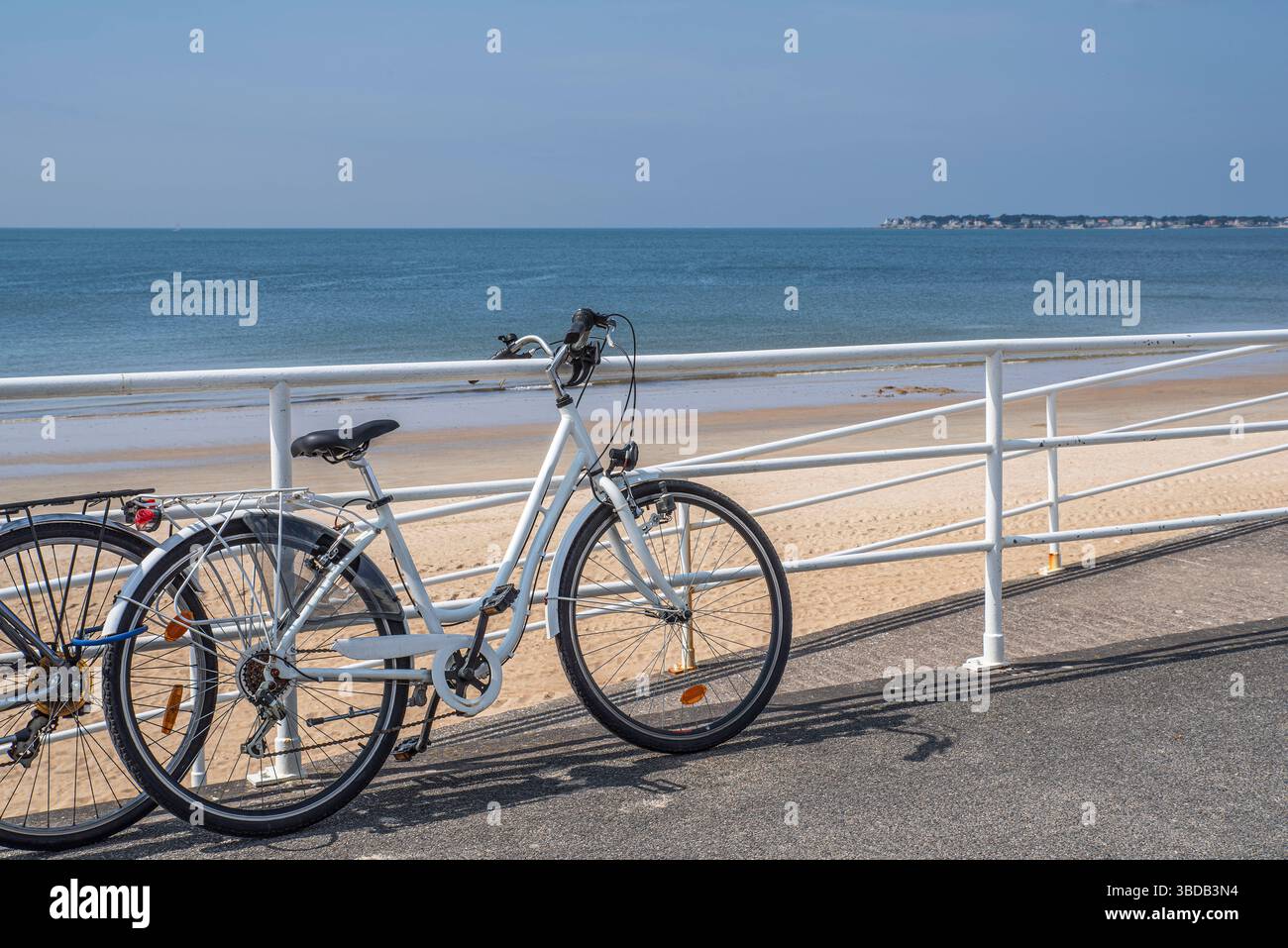 Una bicicletta parcheggiata presso la spiaggia sabbiosa della città di la Baule in Bretagna, in estate Foto Stock