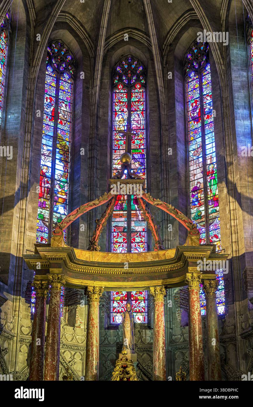 Le vetrate colorate riempiono le finestre absidali curve della chiesa di San salvi ad Albi in Francia, che emettono una luce colorata sull'altare dorato ornato nel coro. Foto Stock