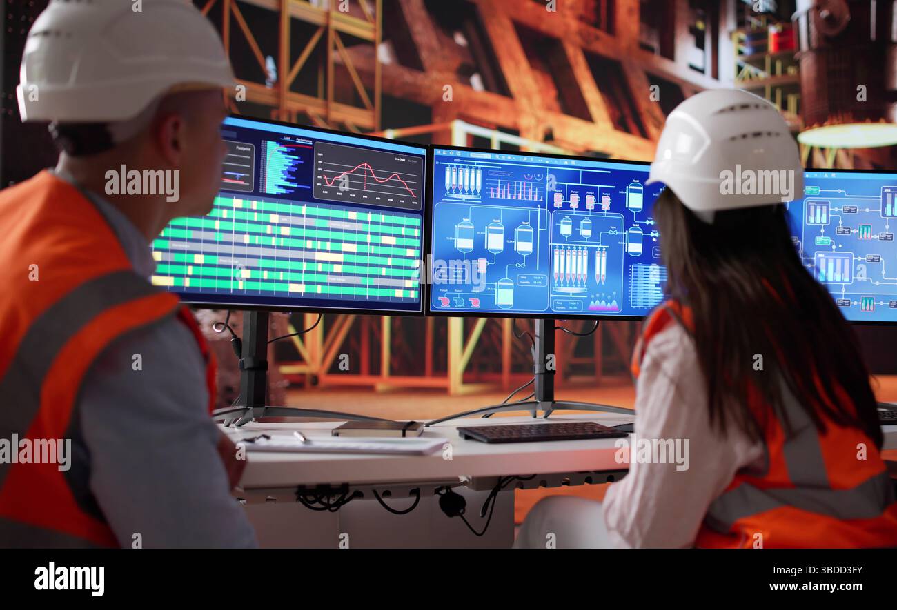 Team di giovani lavoratori che utilizzano il sistema SCADA nella fabbrica di ferro Foto Stock