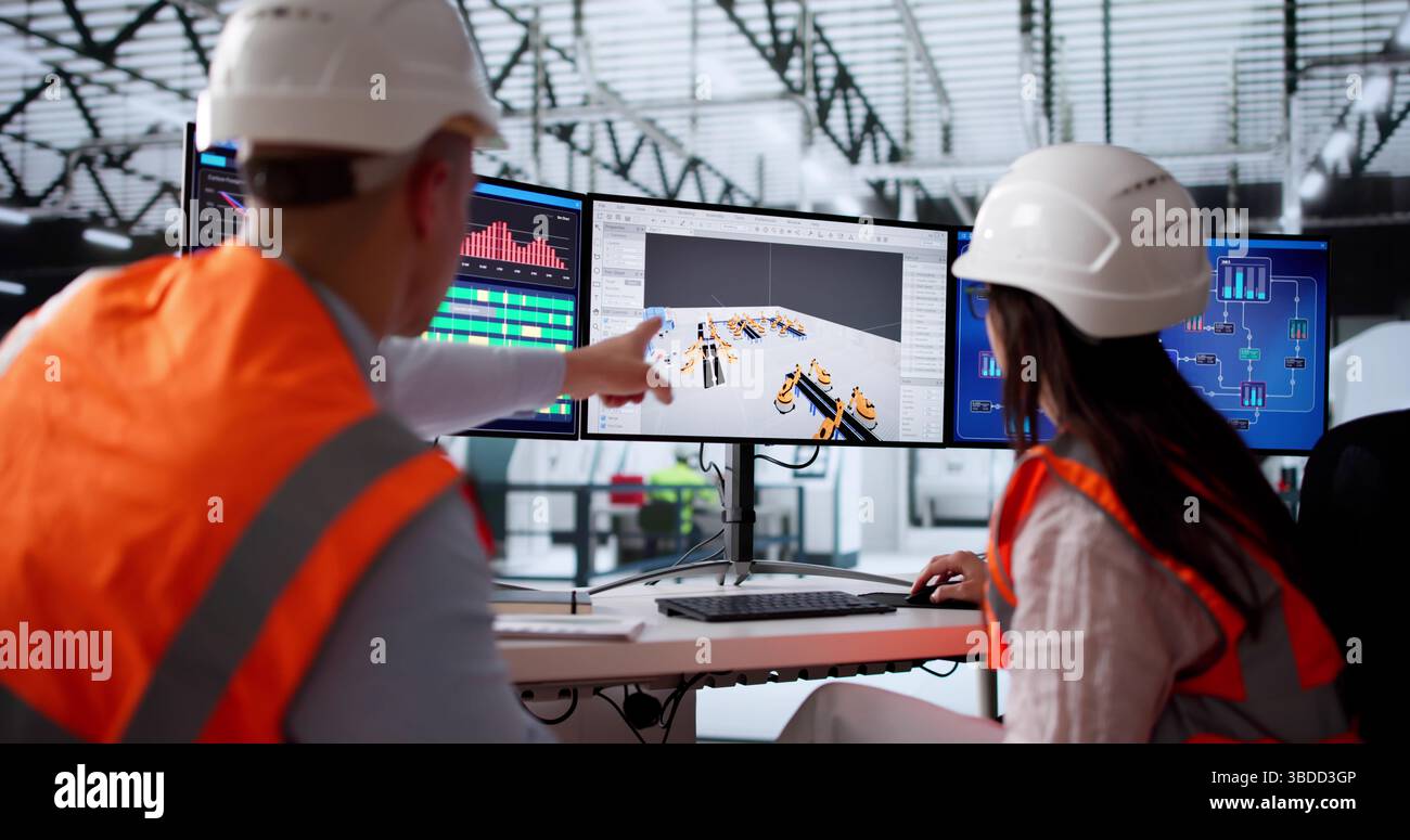 Young Engineer Mapping Out Machinery Layout in New Industrial Facility. Foto Stock