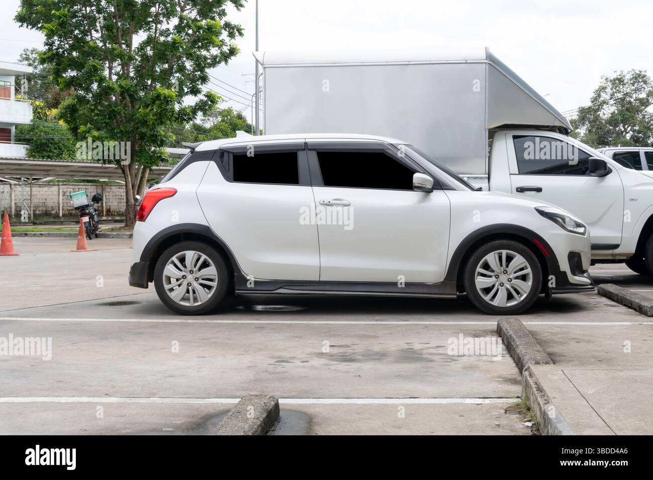 La vista sul lato destro della mini auto berlina bianca è il parcheggio all'aperto dei grandi magazzini. Foto Stock