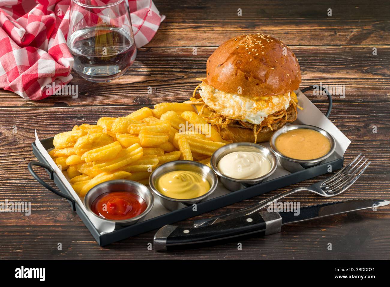 Hamburger con patate croccanti servito con patatine fritte e salse Foto Stock