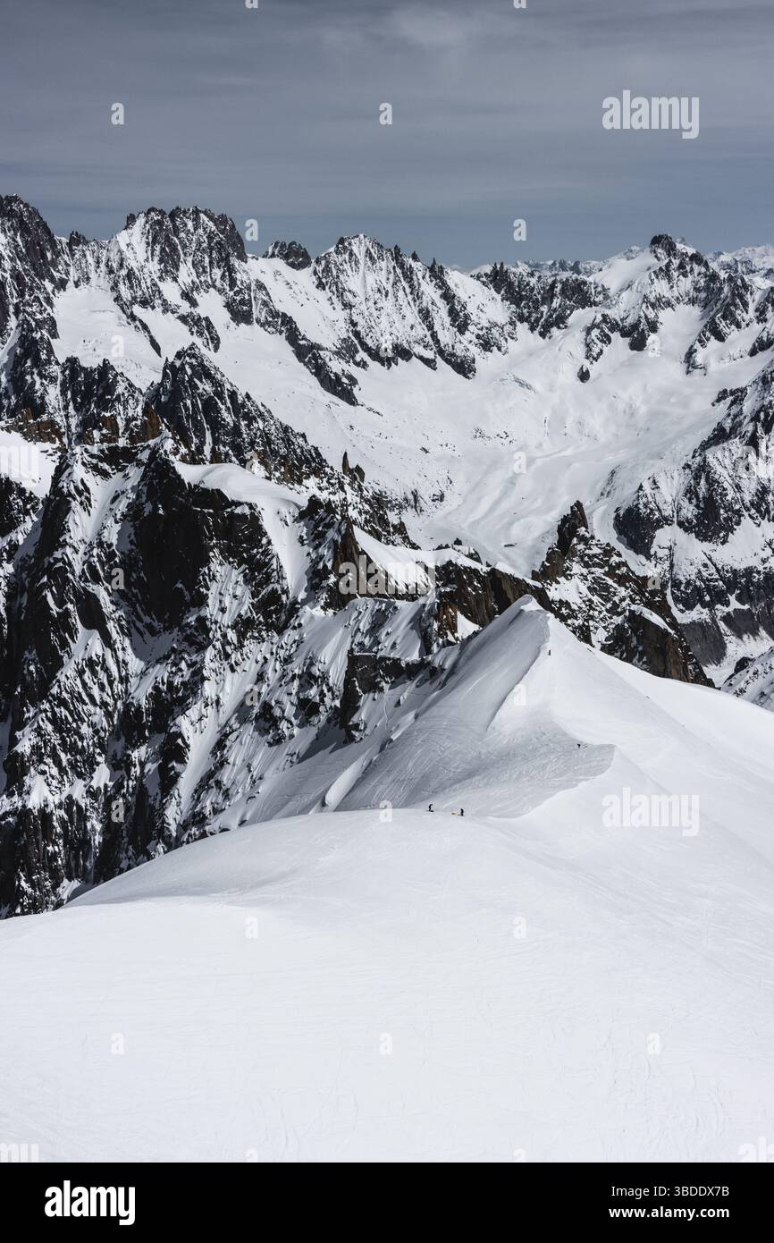 Scialpinisti su una splendida cresta vicino a Aigulle du Midi nel massiccio del Monte bianco nelle alpi francesi sopra Chamonix, con uno scenario montano spettacolare. Foto Stock