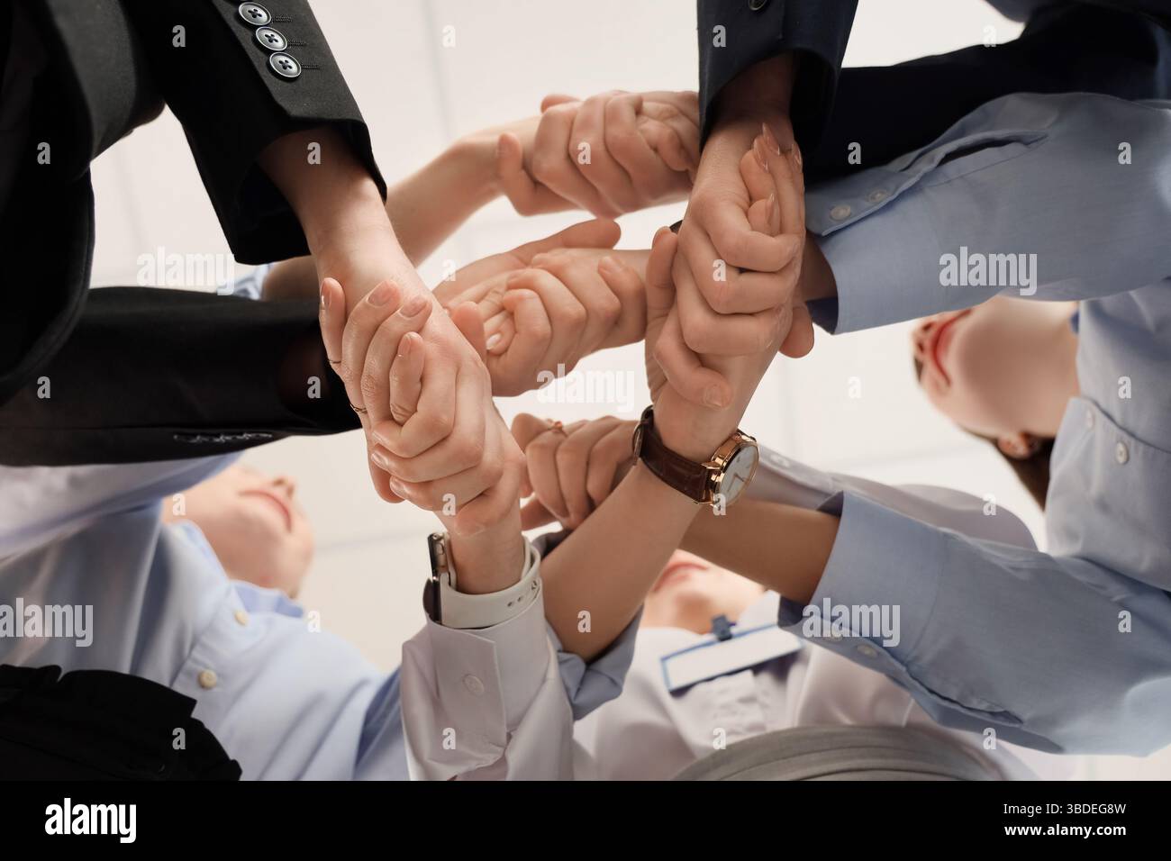 Uomini d'affari che stringono la mano dopo le negoziazioni in ufficio, vista dal basso Foto Stock