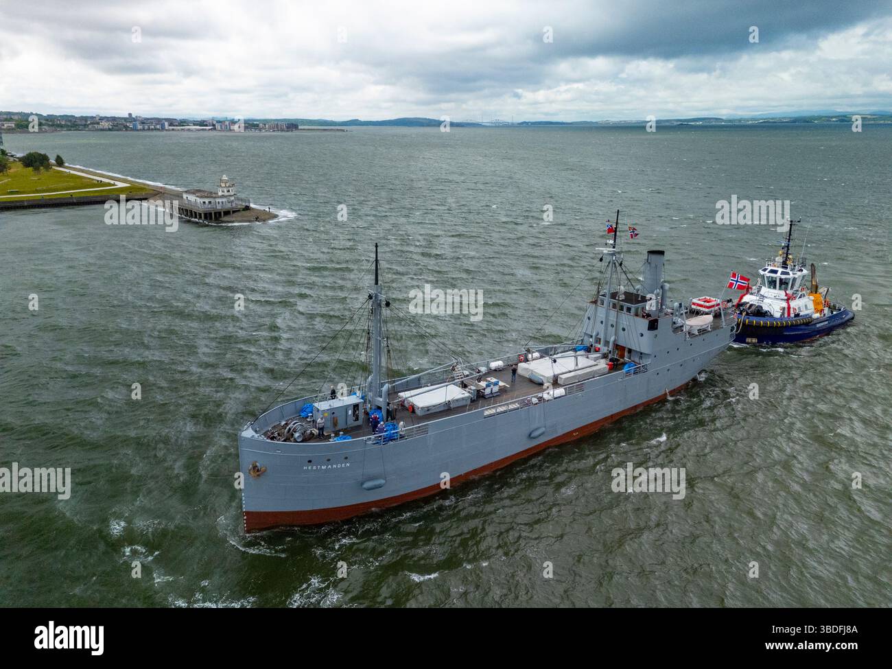 Leith, Edimburgo, Scozia, Regno Unito. 24 maggio 2025. La storica nave norvegese S/S Hestmanden arriva oggi al porto di Leith. La nave mercantile da carico di 114 anni, l'unica nave da carico conservata ad aver navigato in convogli durante la prima e la seconda guerra mondiale, sarà ormeggiata a Leith e aperta al pubblico. Soprannominata “la nave fortunata” per i convogli sopravvissuti in tempo di guerra in due conflitti globali, la Hestmanden è l’unica nave rimasta degli oltre 1.000 che hanno costituito la flotta di Nortraship durante la seconda guerra mondiale. Iain Masterton/Alamy Live News Foto Stock
