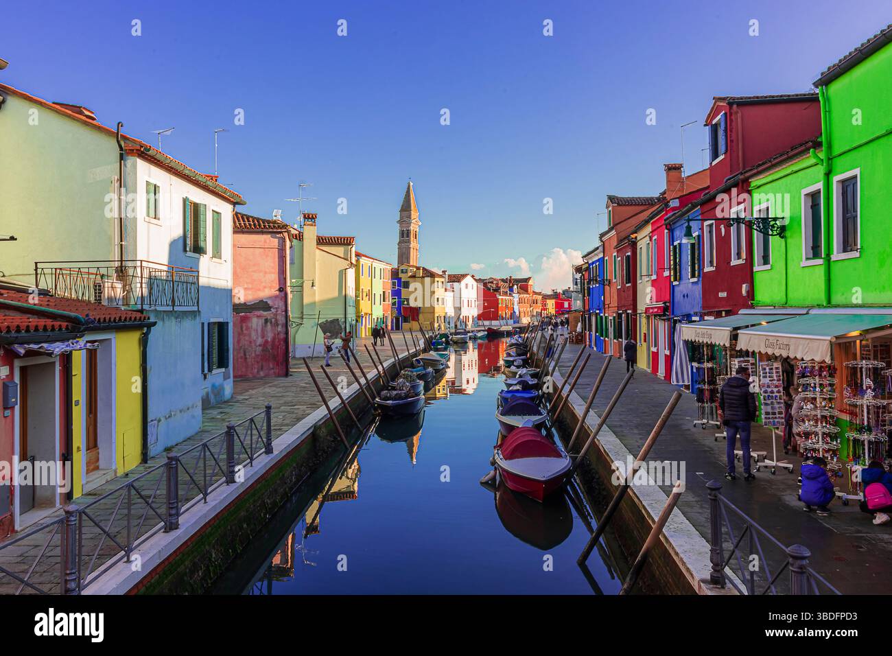 Gli affascinanti canali di Burano con le barche ormeggiate al molo Foto Stock