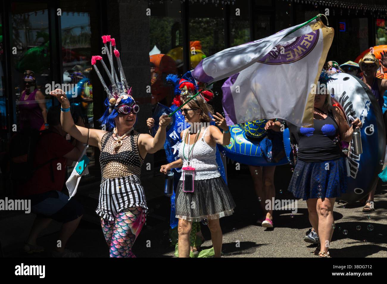 The Big Float, Portland, Oregon - 14 luglio 2018: Le persone in costume da sirena sfilano con una bandiera e creature marine gonfiabili, celebrando il Willamet Foto Stock