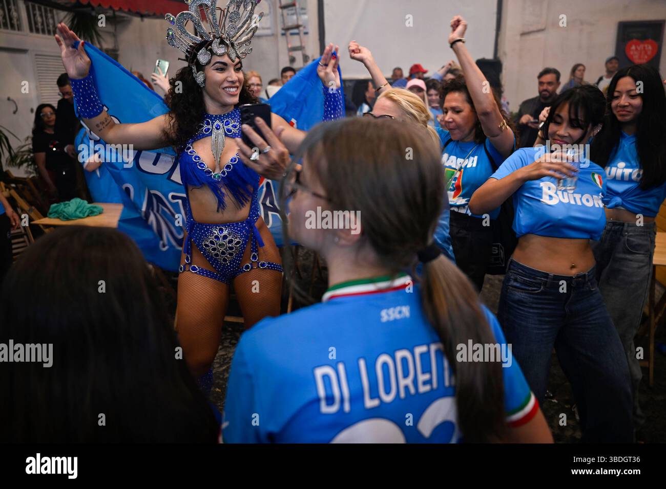 Una ballerina festeggia con i tifosi del Napoli a forcella. Si celebra la vittoria della partita Napoli vs Cagliari in strada con la squadra di calcio del Napoli che ha conquistato il quarto titolo di scudetto. Foto Stock