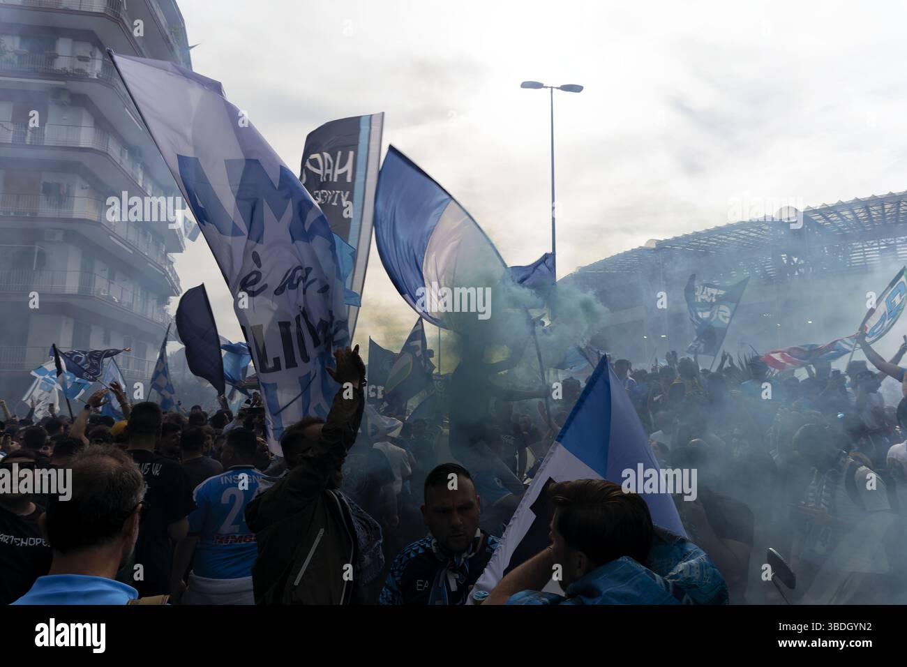 Napoli, Italia – 23 maggio 2025: I tifosi del Napoli festeggiano in strada dopo che il Napoli ha vinto il quarto titolo di serie A, sventolando bandiere e luci a raffica Foto Stock