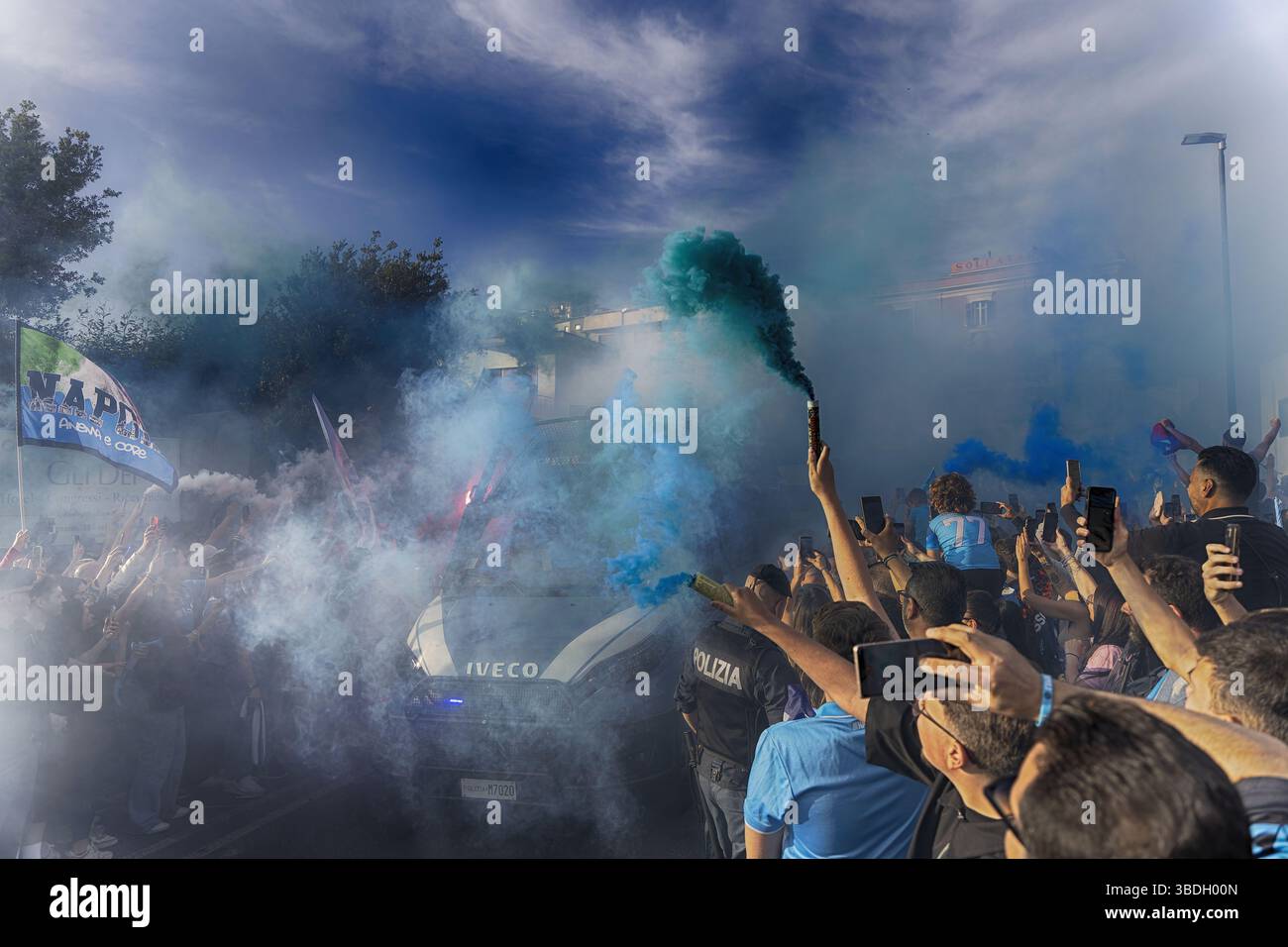 Napoli, Italia – 23 maggio 2025: I tifosi del Napoli festeggiano in strada dopo che il Napoli ha vinto il quarto titolo di serie A, sventolando bandiere e luci a raffica Foto Stock