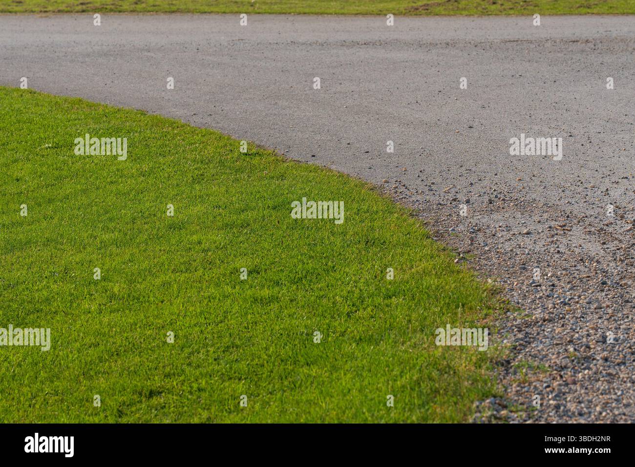Angolo di Tidy Street con erba rifilata e strada curva Foto Stock