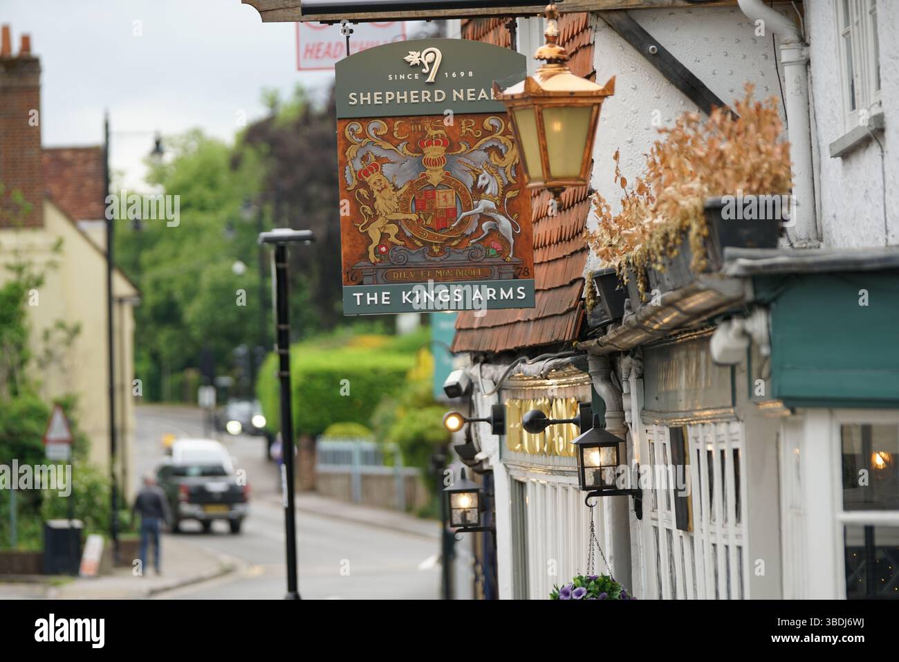 Pub tradizionale inglese con insegna decorativa e lanterne sospese in un pittoresco villaggio. Dorking, Regno Unito Foto Stock