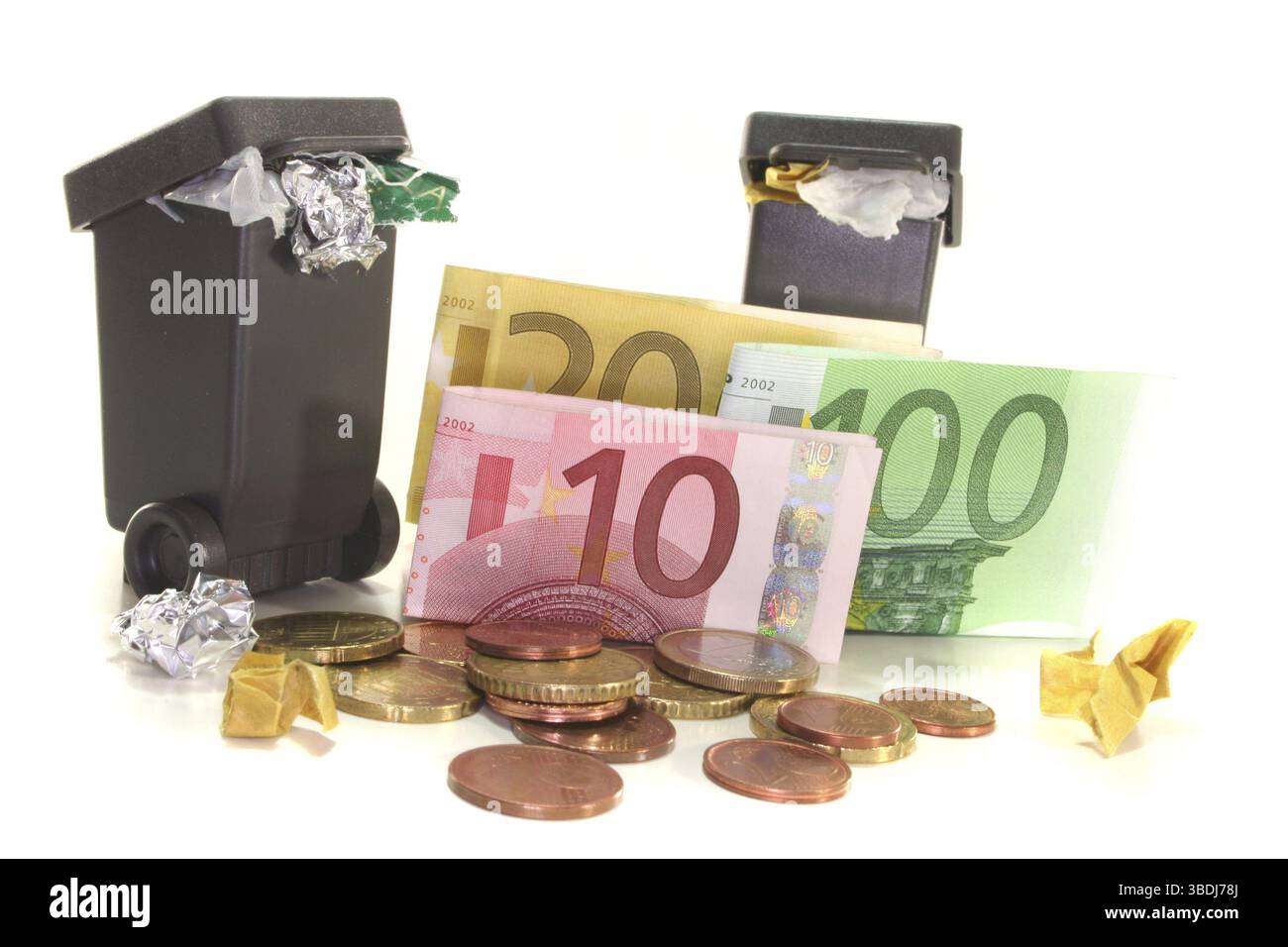 Bidoni completi con banconote e monete in euro su sfondo bianco Foto Stock