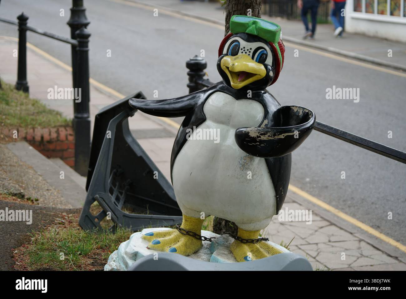 Statua colorata dei pinguini sul marciapiede urbano in un ambiente pieno di luce del giorno. Dorking, Regno Unito Foto Stock
