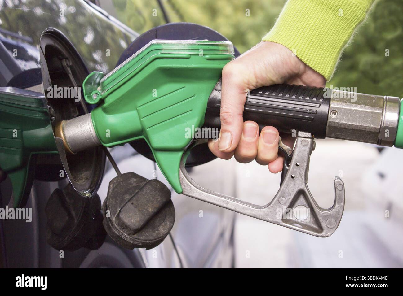 Femmina che riempie il serbatoio dell'auto con benzina all'aperto Foto Stock