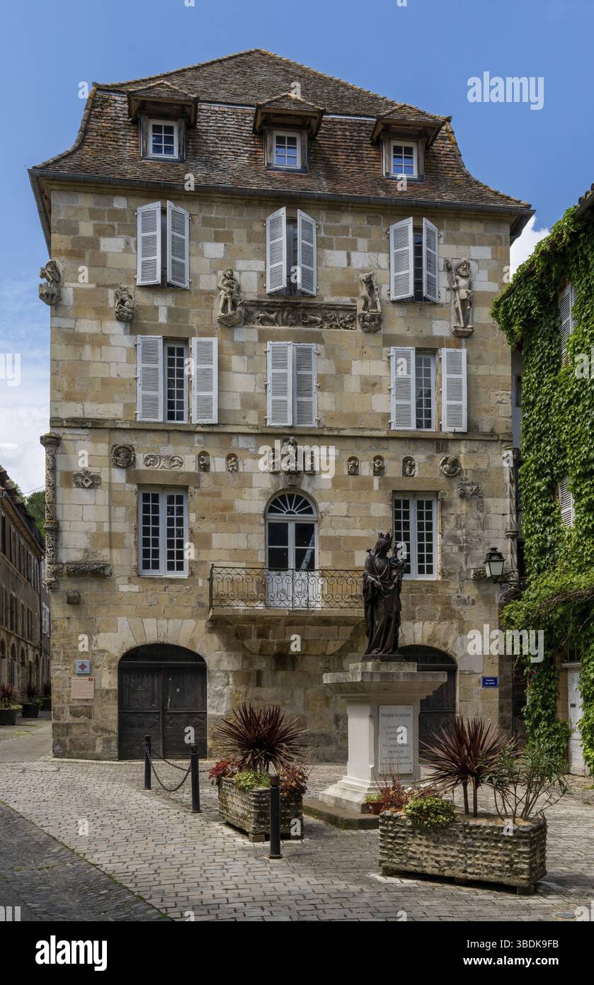 Beaulieu-sur-Dordogne, Francia - 13 maggio, 2022: Edificio storico borghese e statua nel centro della città fortificata di Beaulieu-sur-Dordogne Foto Stock