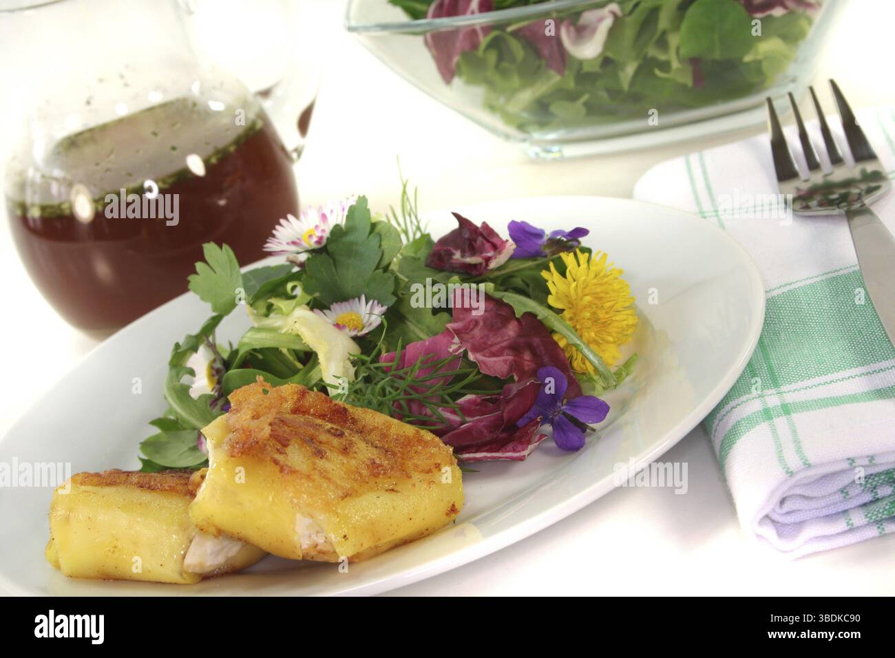 Insalata di erbe selvatiche con formaggio di capra ricoperto di patate su sfondo bianco Foto Stock