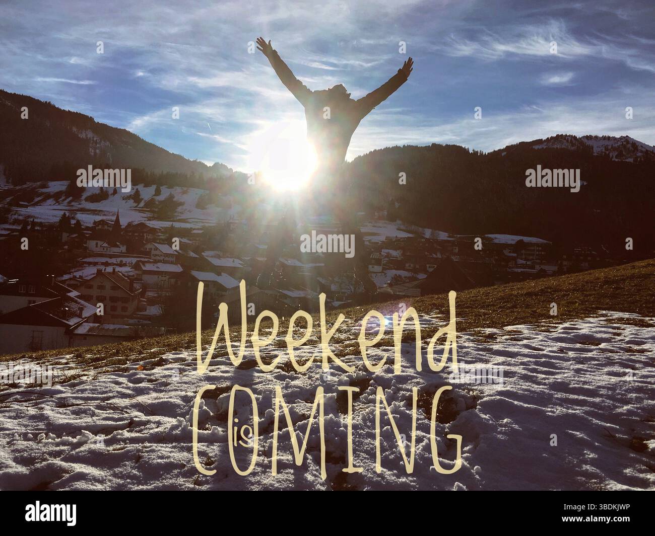 Uomo irriconoscibile che salta con le braccia sollevate davanti alla vista della montagna contro il sole. Text „ Weekend sta arrivando ", concetto di motivazione, guardare avanti Foto Stock