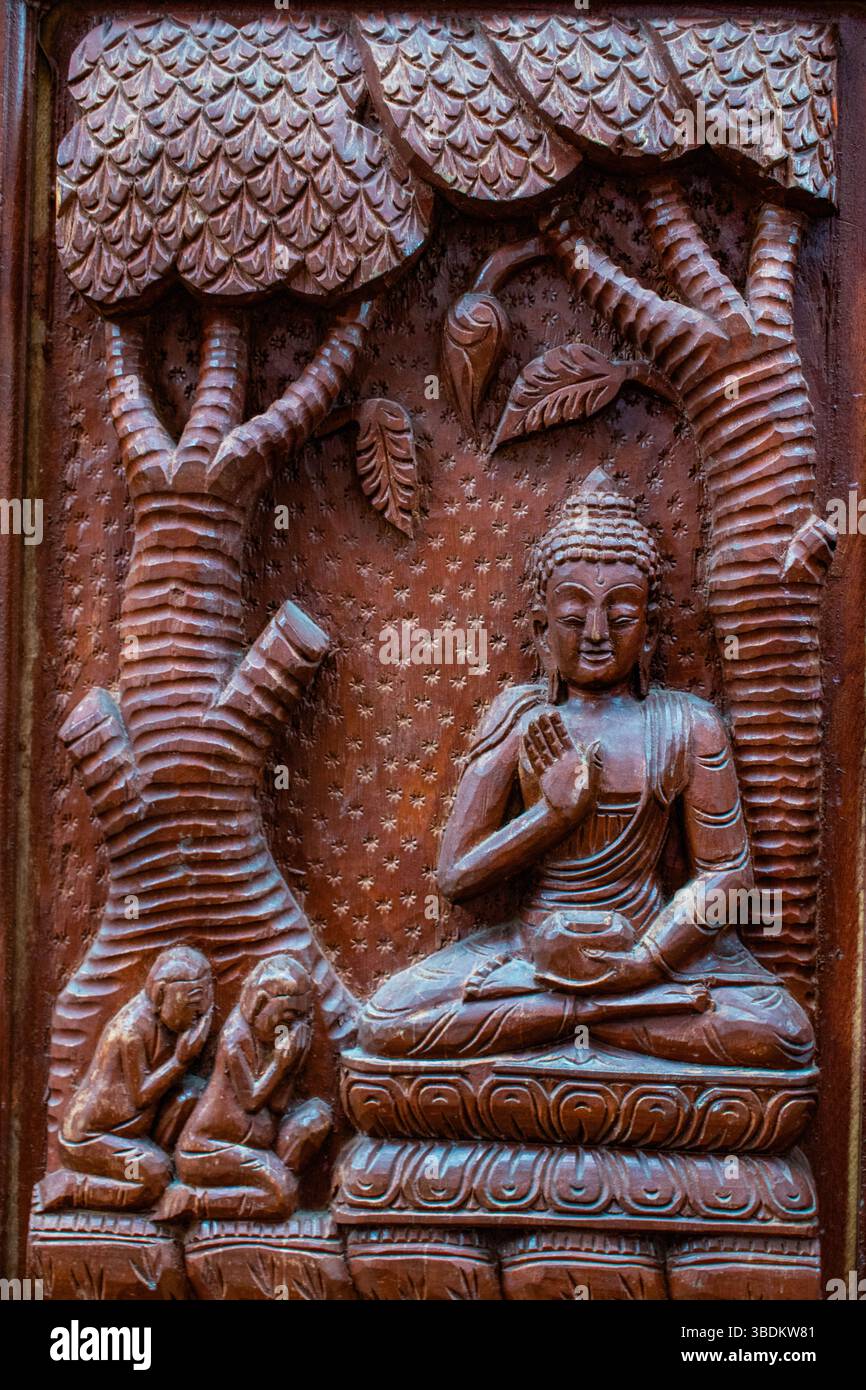 Nepal: Dettagli di una porta di legno decorata con episodi della vita del Buddha a Bhaktapur, città famosa per la sua tradizione newar e gli artigiani Foto Stock