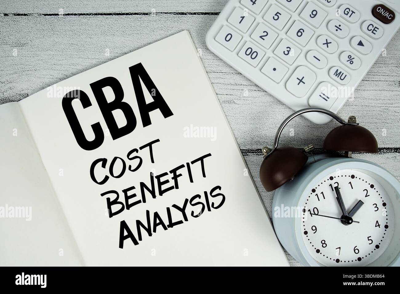 Testo CBA Cost Advantage Analysis su pagina notebook cartacea con sveglia e calcolatrice su sfondo in legno Foto Stock