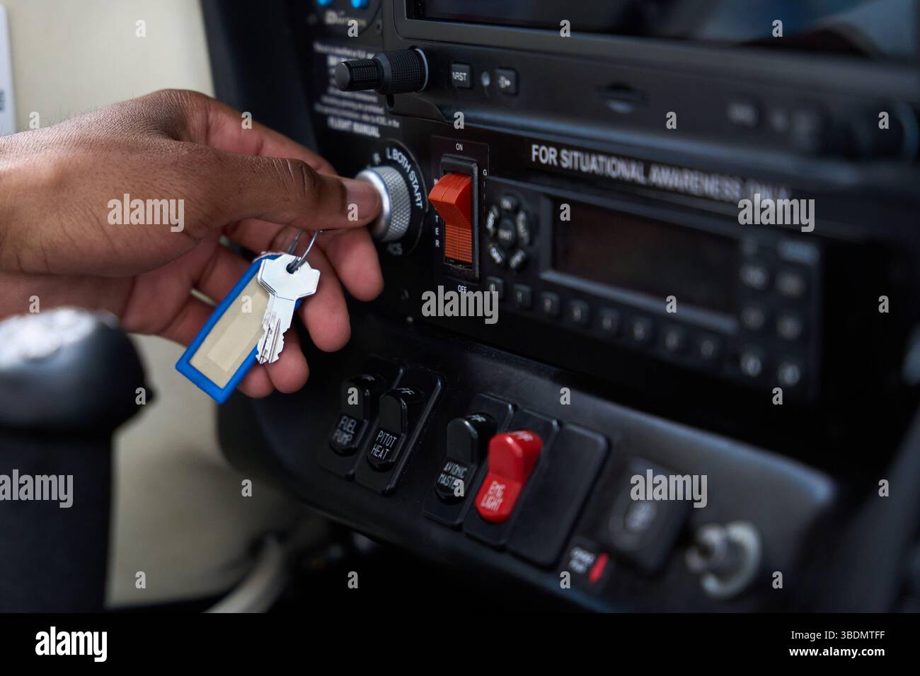 Pilota che inserisce la chiave nel commutatore di accensione del pannello della cabina di pilotaggio dell'aeromobile Foto Stock