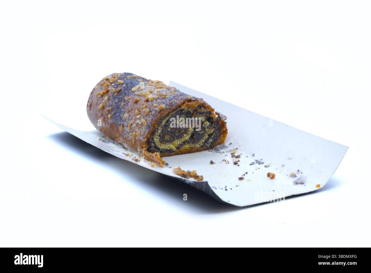 Primo piano di un rotolo di semi di papavero con glassa di zucchero e noci tritate, parzialmente mangiate, poste su un vassoio di carta bianca Ideale per annunci di prodotti da forno e confezionamento di alimenti Foto Stock